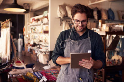 man with apron looking at a clipboard