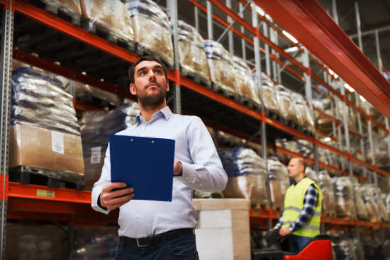 man in warehouse holding a clipboard