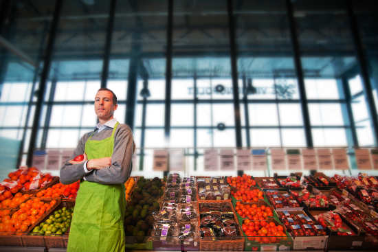 man standing in front of produce stand