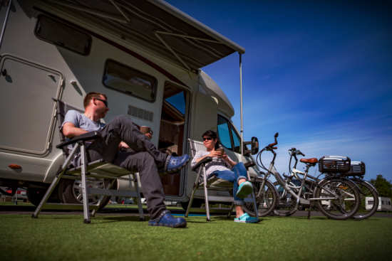 man and woman sitting outside a motorhome