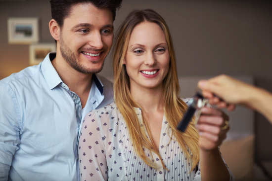 man and woman getting handed keys